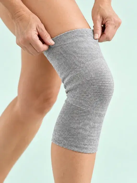 Hands adjusting a gray knit knee sleeve